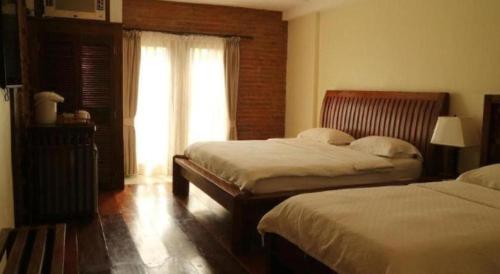 a hotel room with two beds and a window at Mango Valley Hotel in Olongapo