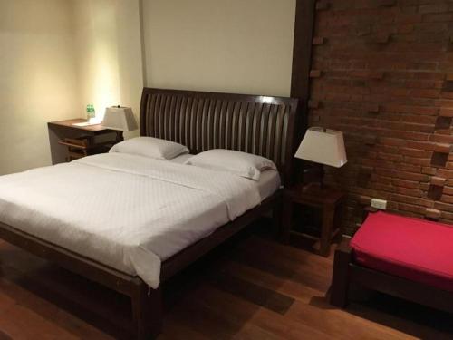a bedroom with a large bed with two tables and two lamps at Mango Valley Hotel in Olongapo