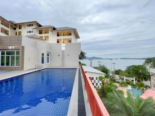 a view of a swimming pool in front of a building at Royal Hill Satun Hotel in Satun