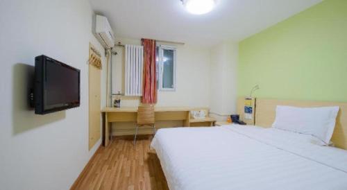 a bedroom with a white bed and a television at 7 Days Premium Beijing Dabaotai Metro Station Luhua Road in Beijing