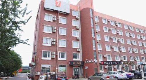 a large red building with cars parked in front of it at 7 Days Premium Beijing Dabaotai Metro Station Luhua Road in Beijing