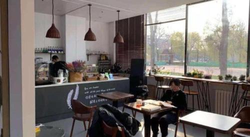 a woman sitting at a table in a restaurant at 7 Days Premium Beijing Dabaotai Metro Station Luhua Road in Beijing