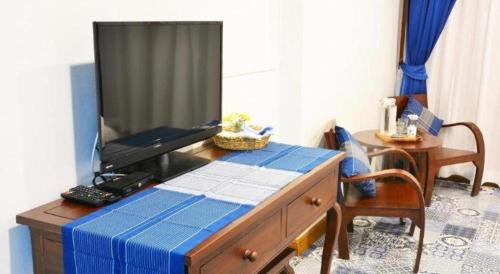 a television sitting on top of a wooden desk at The Indigo House Phrae in Phrae