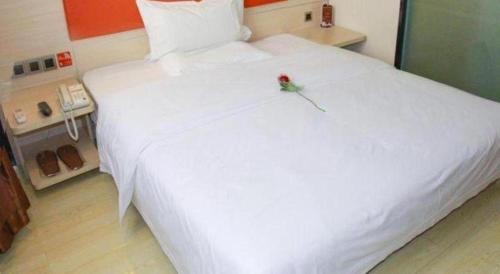 a bedroom with a white bed with a flower on it at 7 Days Premium Beijing Dabaotai Metro Station Luhua Road in Beijing