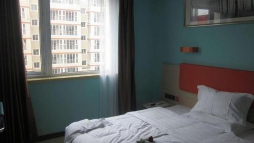 a bedroom with a white bed with a window at 7 Days Premium Beijing Dabaotai Metro Station Luhua Road in Beijing