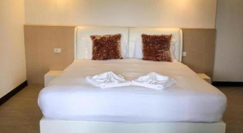 a large white bed with two white towels on it at C View Home in Nan