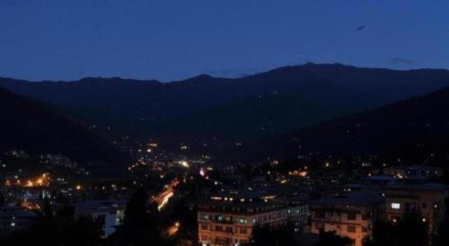 a view of a city at night with mountains at Khang Residency Thimphu in Thimphu