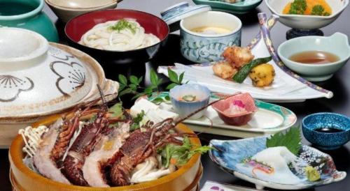a table with plates of food and bowls of soup at Futami Onsen Hotel Seikai in Ise