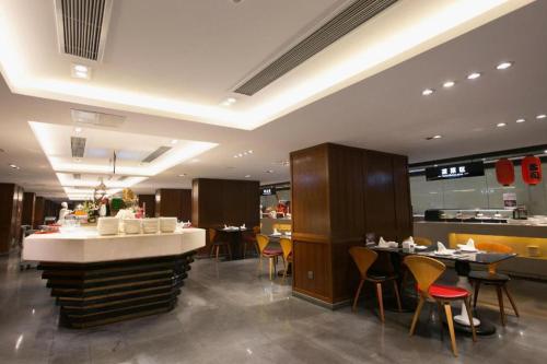 a restaurant with tables and chairs and a counter at Yongzhou Chuang Fa Cheng XiaoXiangYi Hotel in Guzhuting