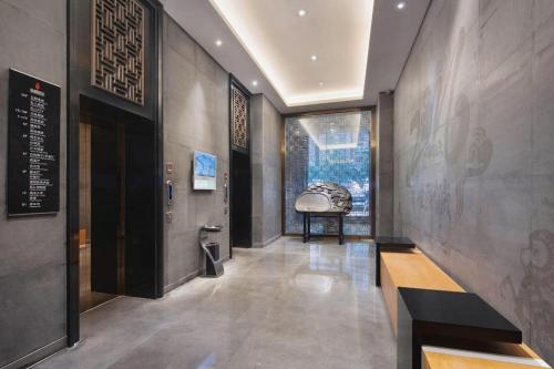a hallway of a museum with a bench and a window at Yongzhou Chuang Fa Cheng XiaoXiangYi Hotel in Guzhuting