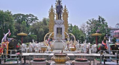 a fountain in a park with a statue on top at Tonkok Hotel in Chiang Rai