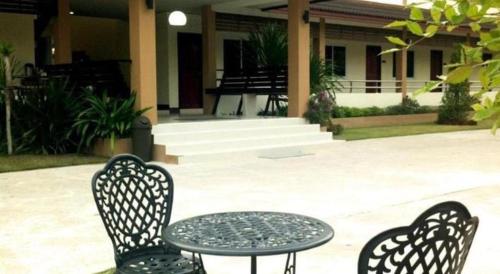 three chairs and a table in front of a building at Baan Ing Daan in Amnat Charoen
