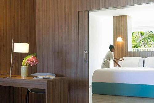 a woman in a hotel room with a bed at EXCELLENCE PUNTA CANA - ALL INCLUSIVE - ADULTS ONLY in Punta Cana