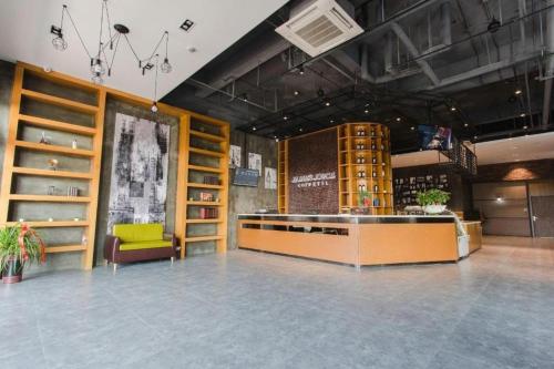 a large room with a counter and a yellow chair at James Joyce Coffetel Wuhu Wanzhi High-Speed Railway Station in Wanzhi