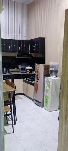 Una cocina con un refrigerador y una mesa dentro. en Homestay Permata Cirebon, en Ciperna