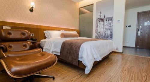 a hotel room with a bed and a chair at James Joyce Coffetel Wuhu Wanzhi High-Speed Railway Station in Wanzhi
