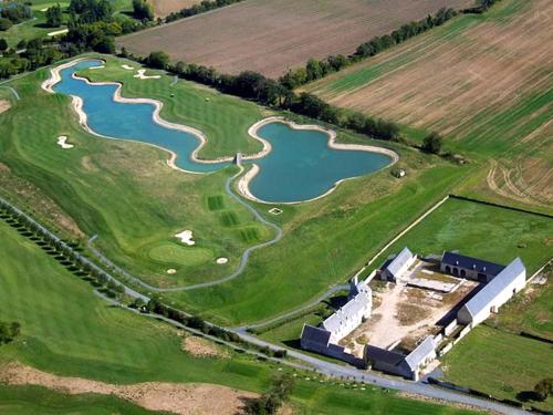 an aerial view of a golf course with a lake at ibis Bayeux Port En Bessin in Port-en-Bessin-Huppain
