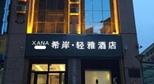 a building with asian writing on the front of it at Xana Lite Korla Shihua Avenue Longquehe in Korla