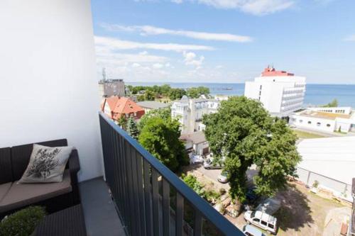 a balcony with a view of a city and the ocean at Horyzont Luksusowe apartamenty nad morzem z parkingiem Międzyzdroje in Międzyzdroje