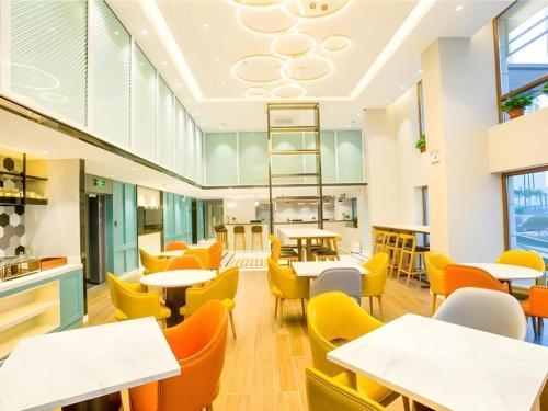 an empty restaurant with tables and chairs at Magnotel Harbin Songbei Wanda Wenlvcheng in Harbin