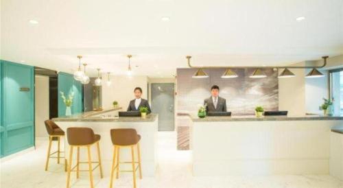two men in suits sitting at a bar in an office at Magnotel Harbin Songbei Wanda Wenlvcheng in Harbin