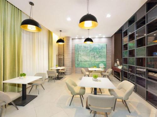 a restaurant with tables and chairs and a large painting at Jinjiang Inn Select Tianjin Xiaobailou Metro Station in Tianjin