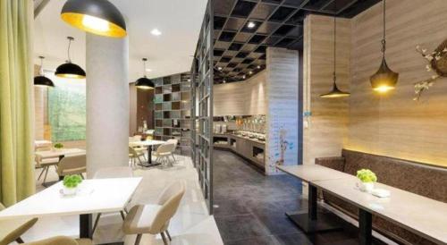a restaurant with white tables and white chairs and tablesearcher at Jinjiang Inn Select Tianjin Xiaobailou Metro Station in Tianjin