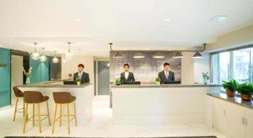 three men in suits sitting at a bar in an office at Magnotel Harbin Songbei Wanda Wenlvcheng in Harbin