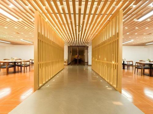 a hallway with wooden walls and tables in a room at Jinjiang Inn Select Xuzhou High-speed Railway Station Kunpeng Road in Xuzhou