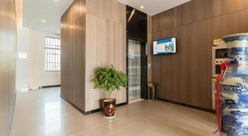a hallway with a vase and a plant on the floor at Jinjiang Inn Select Xuzhou High-speed Railway Station Kunpeng Road in Xuzhou