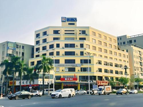 a large building with cars parked in a parking lot at PAI Hotel Zhuhai Doumen Daxin Xinduhui Bus Terminal in Zhuhai