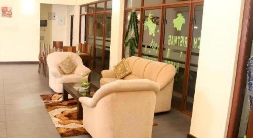 a living room with two chairs and a table at Talawakele Rest House in Nuwara Eliya
