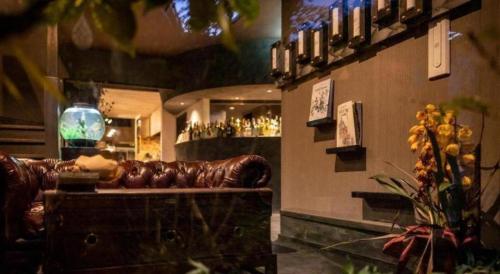 a brown leather couch in a room with a bar at Yufuin Luxury Villa -zakuro- in Yufuin