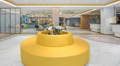 a yellow bench in the middle of a lobby at Magnotel Hotel Jining Yanzhou Metro Station Jiuxianqiao South Road in Jining