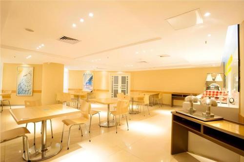 a restaurant with tables and chairs in a room at City Comfort Inn Wuhan Ikea in Wuhan