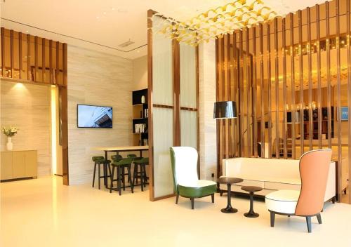 a lobby with chairs and a table and a television at City Comfort Inn Wuhan Ikea in Wuhan