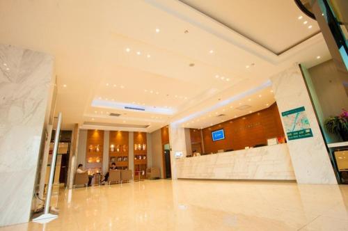 a lobby of a building with a person sitting at a table at City Comfort Inn Wuhan Ikea in Wuhan