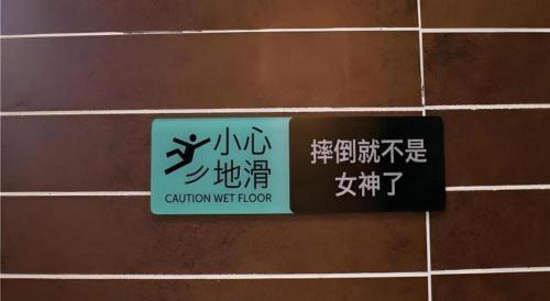 a sign on the side of a wall with writing at Xana Hotelle·Ji'nan Hi-tech Zone Century Avenue Tangye in Jinan