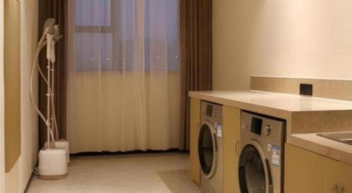 a laundry room with a washer and dryer at City Comfort Inn Wuhan Ikea in Wuhan