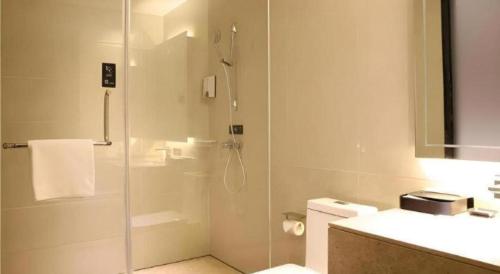 a bathroom with a shower with a glass door at City Comfort Inn Wuhan Ikea in Wuhan