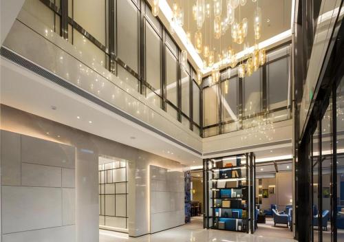 a lobby of a building with a chandelier at Echarm Hotel Changsha High-speed Railway Station in Changsha