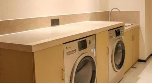 a kitchen with a counter with a washing machine at City Comfort Inn Wuhan Ikea in Wuhan