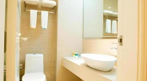 a bathroom with a white sink and a toilet at City Comfort Inn Wuhan Ikea in Wuhan