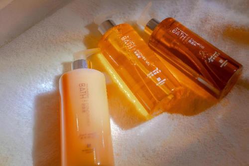 a bottle of sunscreen and a bottle of orange liquid at Borrman Hotel Zhanjiang Shimao Building High-speed Railway Station in Zhanjiang