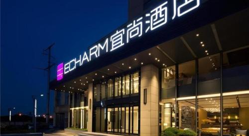 a building with a sign on top of it at night at Echarm Hotel Changsha High-speed Railway Station in Changsha
