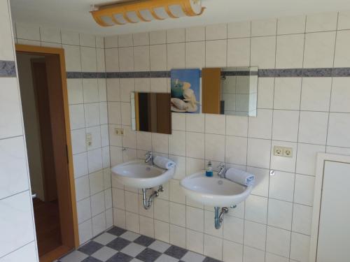 ein Badezimmer mit zwei Waschbecken und zwei Spiegeln in der Unterkunft Villa Fink in Schramberg