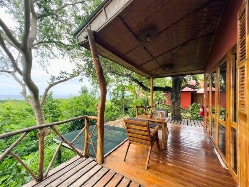 a wooden deck with a table and a chair on it at Nakabalo Guesthouse & Restaurant in Siquijor
