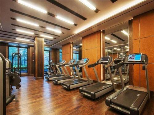 a gym with a row of treadmills at Echarm Hotel Yingshang High-speed Railway Station Wuzhou Wanhui Plaza in Fuyang