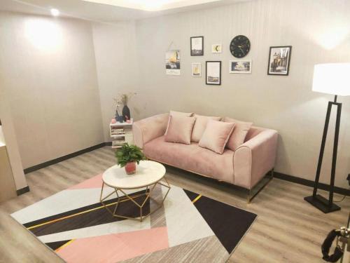 a living room with a couch and a table at Echarm Hotel Yingshang High-speed Railway Station Wuzhou Wanhui Plaza in Fuyang