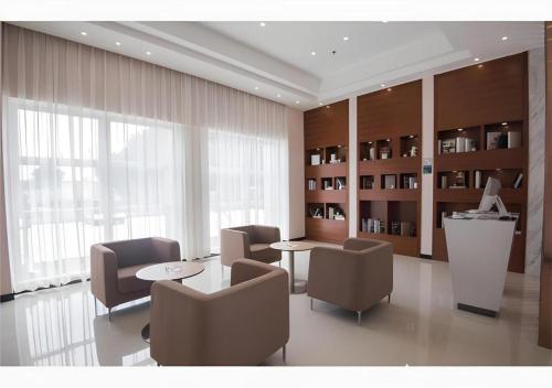 a waiting room with chairs and a table and a desk at City Comfort Inn Shantou Daxue Road in Shantou